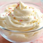 A bowl of light and fluffy Cool Whip and pudding frosting, topped with colorful sprinkles